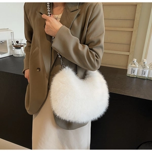 Détail d'un sac lune en fausse fourrure blanche avec bandoulière à billes argentées