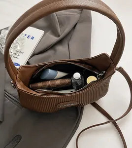 Detail of pleated shoulder bag interior showing spacious capacity and inner zipper pocket