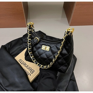 Dettaglio borsa hobo nera trapuntata con catena dorata e chiusura girevole in metallo