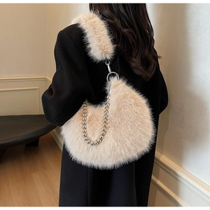 Détail d'un sac demi-lune en peluche beige avec texture douce et chaîne à perles argentée