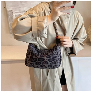 Spiegelselfie der Hobo-Tasche mit Leopardenmuster und Metallkette auf einem Trenchcoat
