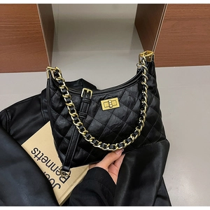 Dettaglio borsa a spalla in pelle trapuntata nera con catena dorata e chiusura a scatto