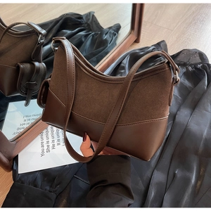Nahaufnahme der braunen Wildleder- und Glattleder-Nähte an einer Vintage-Hobo-Tasche