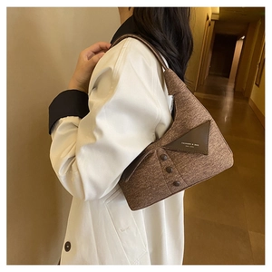 Détail du sac à bandoulière en tissu marron avec patch en cuir mode et boutons décoratifs