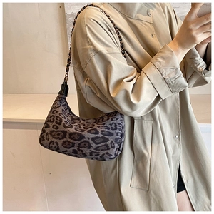 Detail einer Leopard-Hobo-Tasche mit goldener Kettenriemen am Trenchcoat getragen