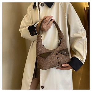 Détail du sac hobo en toile marron avec rabat triangulaire en cuir et boutons décoratifs