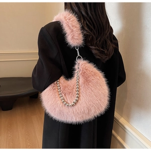 Détail du sac croissant en peluche rose avec chaîne à billes argentées et texture douce
