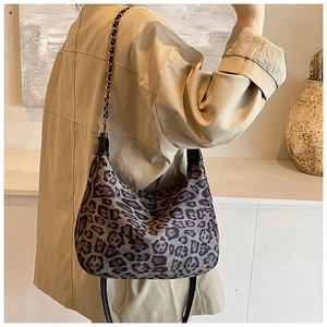 Fashionable leopard print underarm bag with metal chain strap shown on a model