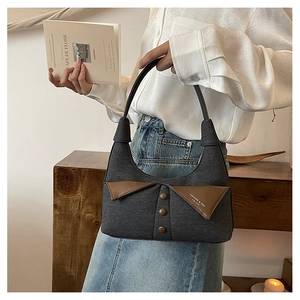 Détail du sac bandoulière en toile grise avec col en cuir marron et design bouton vintage