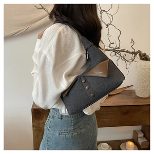 Détail du sac à bandoulière en denim gris avec rabat vintage et boutons décoratifs