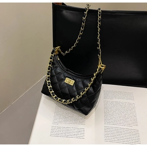 Dettaglio borsa a mezzaluna in pelle nera trapuntata con catena d'oro e chiusura metallica