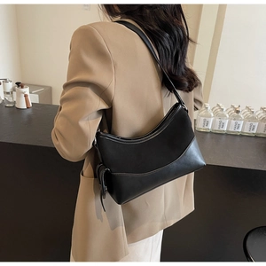 Schwarze Retro-Einkaufstasche kombiniert mit einem beigen Blazer für den Pendler-Look
