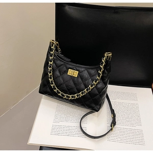Dettaglio borsa hobo trapuntata nera con tracolla a catena dorata e chiusura a scatto