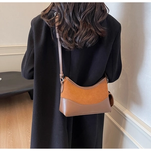 Detail einer braunen Hobo-Tasche aus mattem Wildleder und glattem Kunstleder im Materialmix