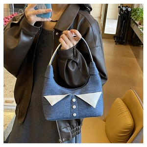 Sac à main chic en denim bleu avec col de chemise blanc montré en selfie miroir