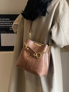 Retro brown leather bucket bag for women with gold chain detail and minimalist strap