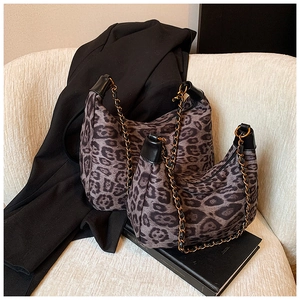 Detailansicht der großen und kleinen Leopard-Taschen im Set auf einem weißen strukturierten Sofa