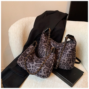 Detailansicht des Leopard-Tote-Sets mit goldenen Ketten auf einem weißen Stuhl