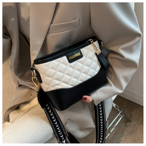 Détail de la couture matelassée sur sac beige et noir avec bandoulière large à motifs