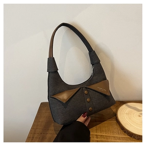 Détail du sac baguette en denim gris avec col en cuir marron et boutons vintage