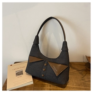 Détail du sac sous le bras en denim gris foncé rétro avec cuir brun et boutons décoratifs
