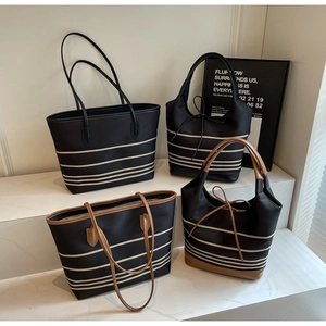 Detailed close-up showing a collection of striped canvas tote bags in various styles
