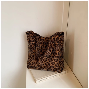 Detail of high-capacity leopard print tote bag with canvas texture and wide shoulder strap