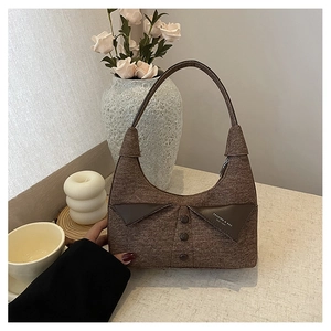 Gros plan détaillé du sac sous le bras en tweed marron avec boutons et empiècement en cuir