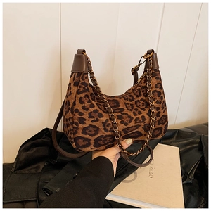 Detail der sichelförmigen Leopard-Tasche mit goldener Kette und braunem Schulterriemen