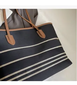 Detailed view of the striped canvas fabric and reinforced stitching on the tote bag