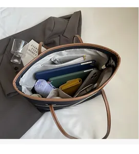 Detail view of large tote interior holding a tablet, umbrella, and wallet with zippered pocket