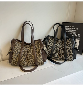 Detail view of large leopard print tote bags in brown and black canvas with leather accents