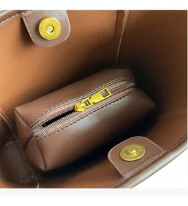 Detail of brown leather tote interior with gold magnetic buckle and matching zipper pouch