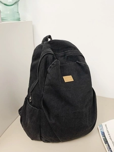 Minimalist black denim backpack with large capacity and brown leather logo patch