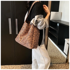 Detailed side view of the large leopard print bucket bag shown on a model for daily use