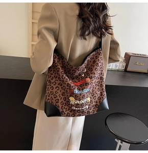 Detail of leopard print tote bag with cartoon dachshunds and leather corner protectors