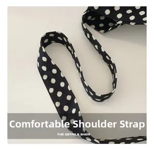 Close-up of comfortable soft shoulder strap on black polka dot canvas tote bag