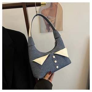Détail du sac bandoulière en denim avec col en cuir blanc et boutons décoratifs
