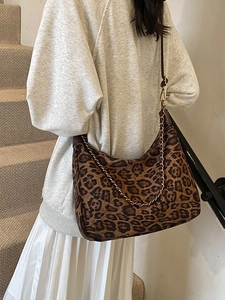 Modische Schultertasche mit Leopardenmuster und goldener Kette am Model gezeigt