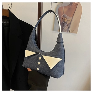 Détail du sac hobo en denim bleu avec revers blanc créatif et boutons décoratifs