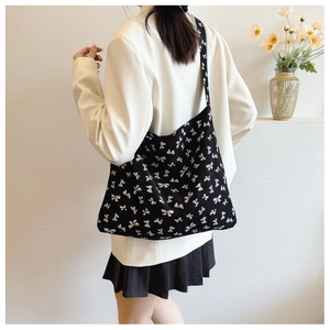 Detail of knit tote bag with black and white bow pattern showing thick woven texture
