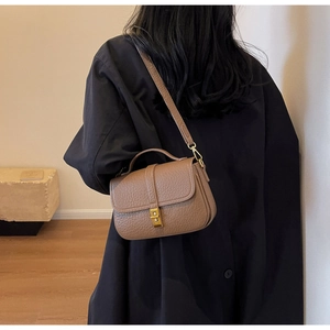Rear view of a model wearing the brown pebble leather crossbody bag with gold hardware