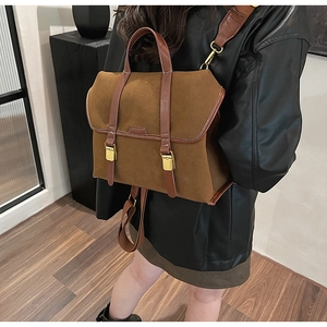 Brauner Vintage-Rucksack aus Wildleder mit dunklen Lederriemen am Model präsentiert