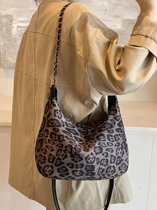 Hobo-Tasche mit Leopardenmuster und Goldkette zu einem eleganten khakifarbenen Trenchcoat