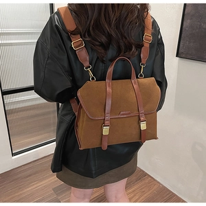 Nahaufnahme des braunen Wildleder-Rucksacks mit Lederriemen und goldener Metallschnalle