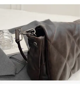 Detailed close-up of dark brown quilted leather bag featuring premium metal hardware