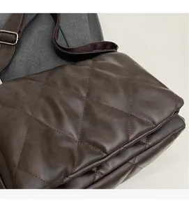 Close-up of dark brown quilted crossbody bag featuring diamond stitching and adjustable strap