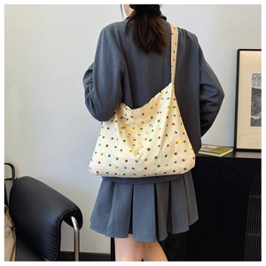 Detailed back view of a large canvas tote bag with colorful polka dots and long straps