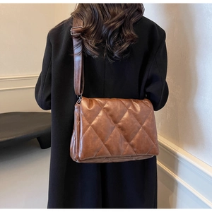 Detailed view of the dark brown quilted crossbody bag featuring elegant diamond stitching