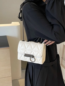 White quilted chain shoulder bag with circular metal clasp and glossy leather finish